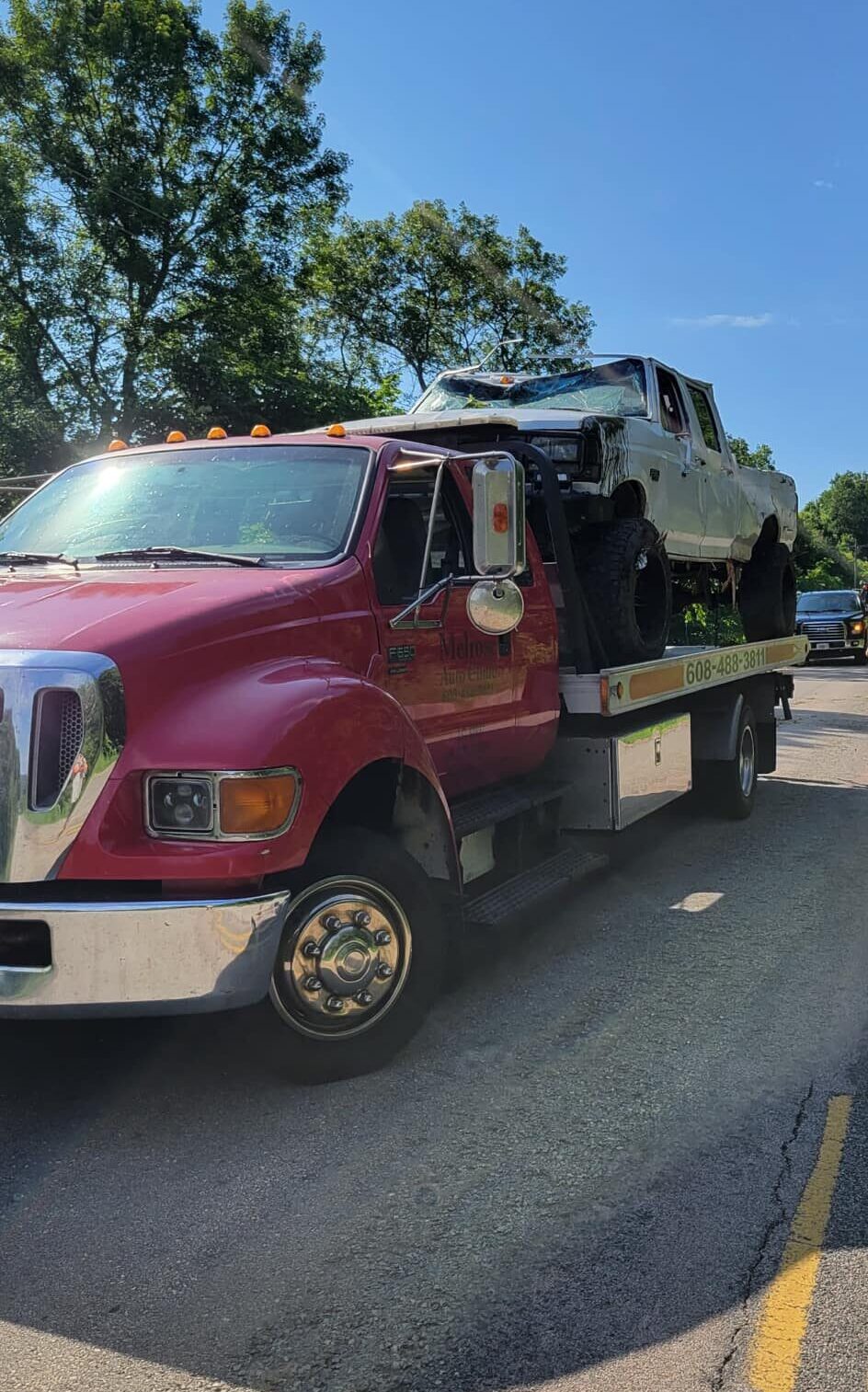 A white truck on the back of a tow truck